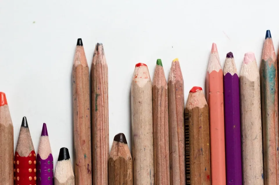 Des crayons de couleur alignés sur un fond clair