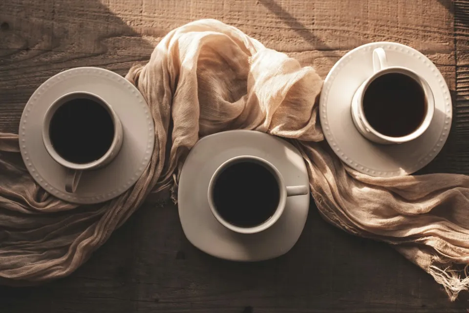 Trois tasses de café vues de dessus sur une table en bois